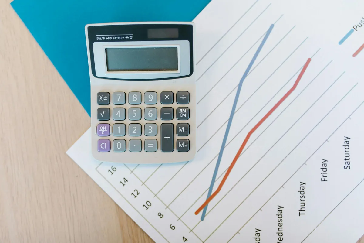Calculator on financial charts and paperwork on a desk
