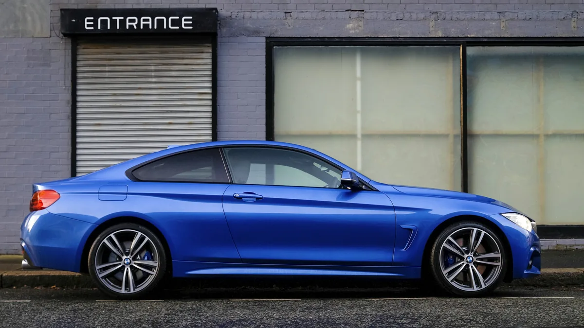Blue passenger car parked on a city street, illustrating auto insurance coverage