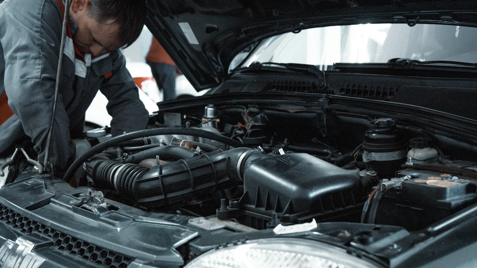 Automotive technician working on a vehicle in a repair garage